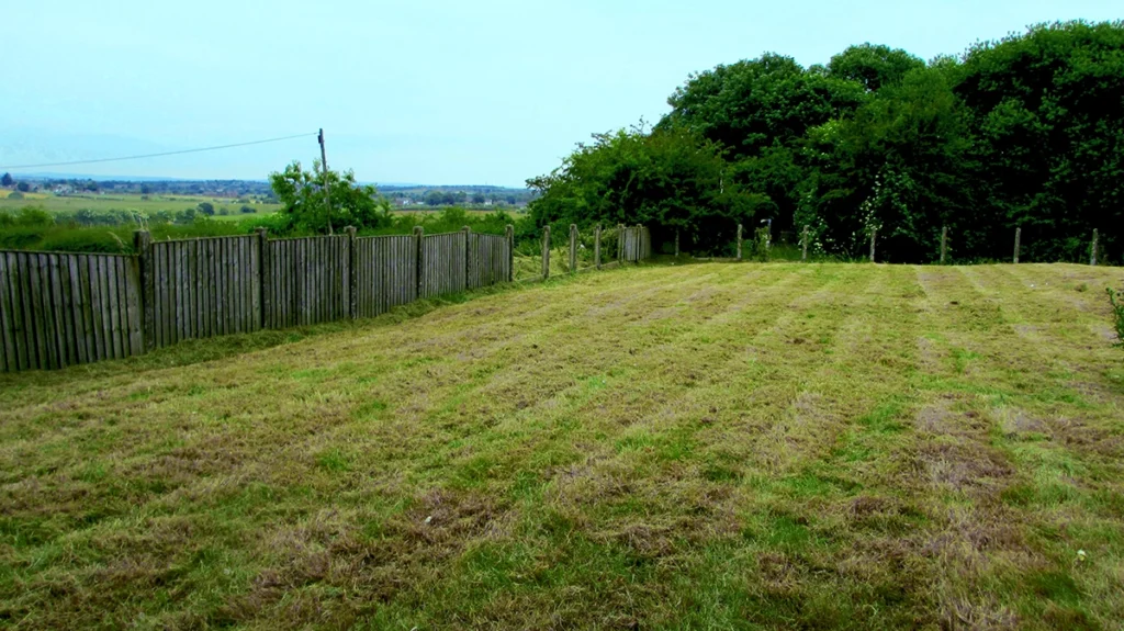 Commercial restaurant in Bolton lawn care services featuring large field size lawn mowing with neat stripes after strimming